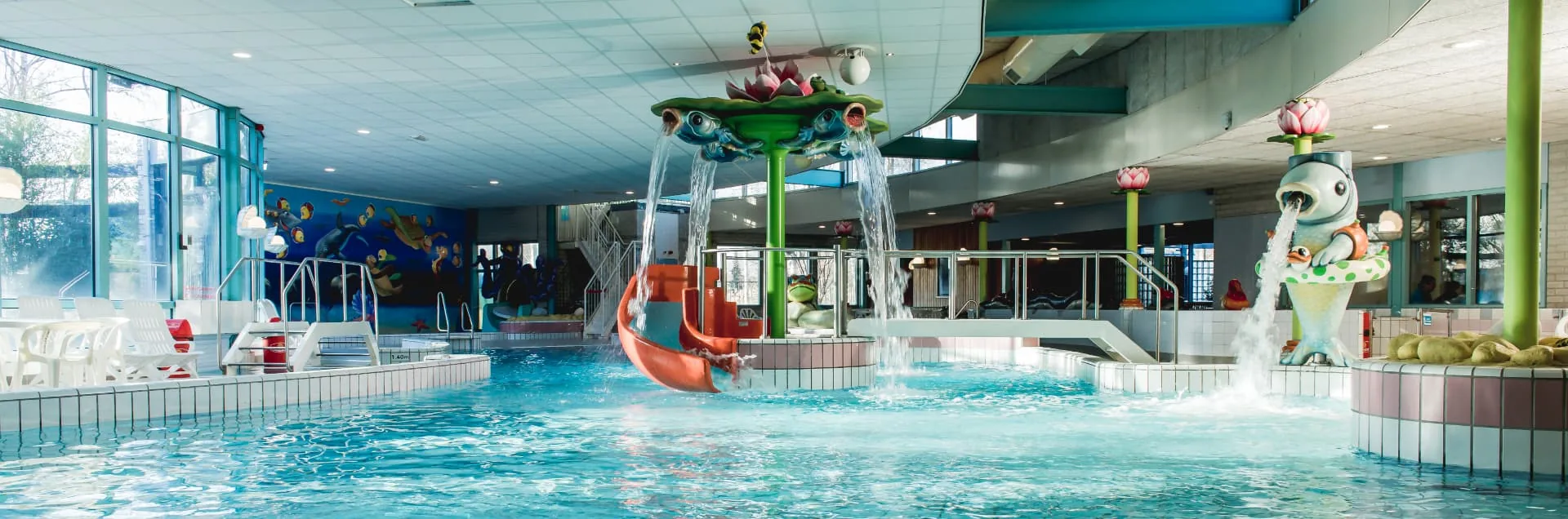 Het recreatiebad van Zwembad De Meerval met fonteinen en waterspeeltoestellen